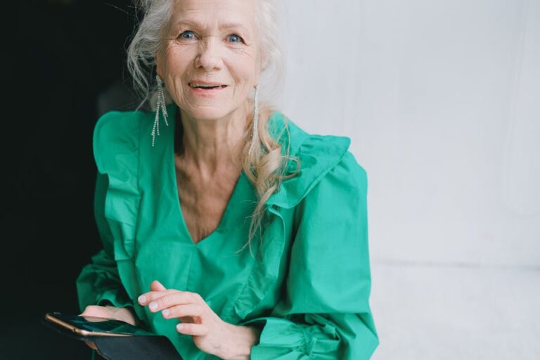 elderly person holding phone smiling - Photo by SHVETS production on Pexels